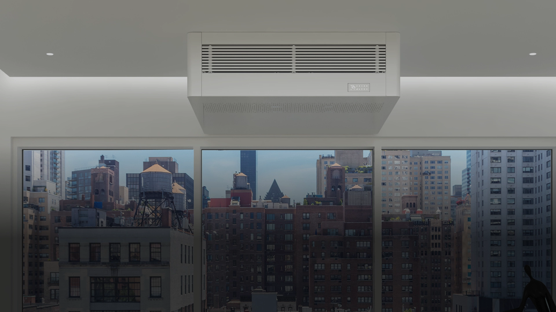 Innova AIO Ceiling Suspended heat pump mounted above a window in a city apartment